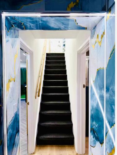 a staircase in a room with blue walls at Birmingham City Centre- 9 bed house with free parking in Birmingham