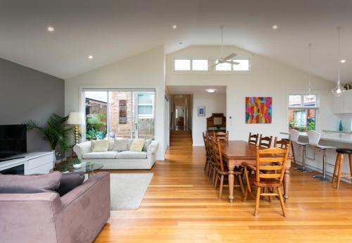 a living room and kitchen with a table and chairs at Beach House Close to Manly in Sydney