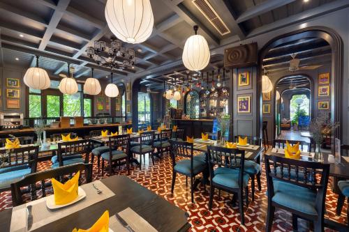 a restaurant with tables and chairs and chandeliers at Son Hoi An Boutique Hotel & Spa in Hoi An