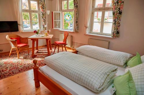 a room with two beds and a table and chairs at Hotel Weisses Ross in Dinkelsbühl
