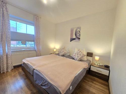 a bedroom with a large bed and a window at Ferienwohnung Ebbe in Dornum