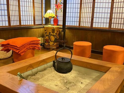 a bathtub filled with sand in a room with orange chairs at Hotel Sejour Mint in Hakuba in Hakuba