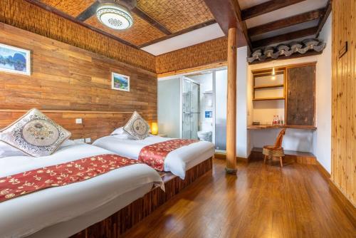 two beds in a room with wooden walls at Nanxun Luohua Old House Inn in Huzhou