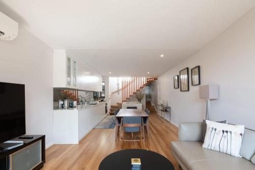 a living room and kitchen with a couch and a table at Modern Home in Erskineville w AC and Parking in Sydney
