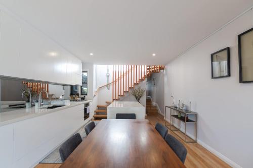 a kitchen and dining room with a long wooden table at Modern Home in Erskineville w AC and Parking in Sydney