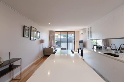 an open kitchen and living room with white walls at Modern Home in Erskineville w AC and Parking in Sydney