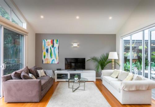a living room with two couches and a tv at Beach House Close to Manly in Sydney