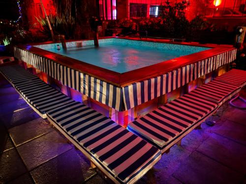 a large swimming pool with benches around it at The White House by Casona Lo Aguirre - El Monte RM in Talagante