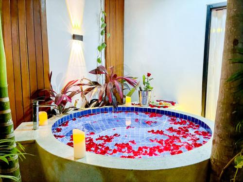 a hot tub filled with red flowers in a room at Cambana La Rivière Hotel in Battambang
