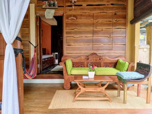 a living room with a green couch and a table at Lafyu Bali in Singaraja