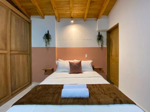 a bedroom with a large bed and wooden ceilings at Prosperity Room - a solo una cuadra del parque in Carmen de Viboral