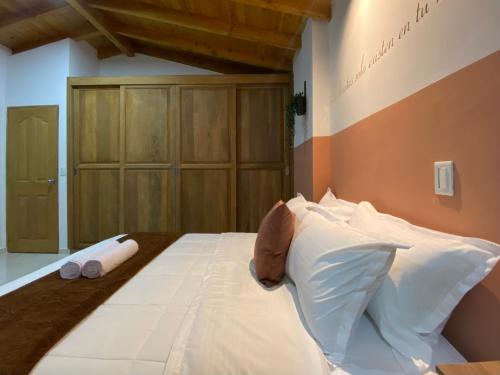 a bedroom with a large bed with white pillows at Prosperity Room - a solo una cuadra del parque in Carmen de Viboral