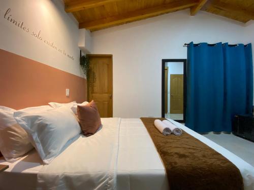 a bedroom with a large white bed with two pillows at Prosperity Room - a solo una cuadra del parque in Carmen de Viboral