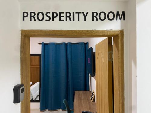 a sign that reads prosperity room above a blue curtain at Prosperity Room - a solo una cuadra del parque in Carmen de Viboral