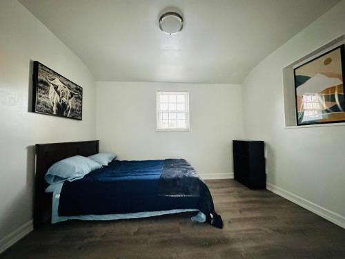 a bedroom with a bed and two pictures on the wall at New Oasis by DC in Hyattsville