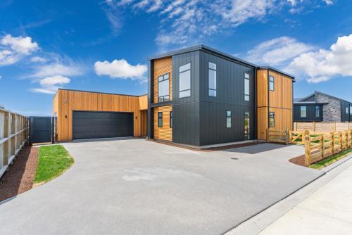 a contemporary house with a black and wooden facade at Wharewaka Escape - Taupo in Taupo
