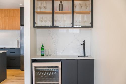 a kitchen with a sink and a counter with wine glasses at Wharewaka Escape - Taupo in Taupo