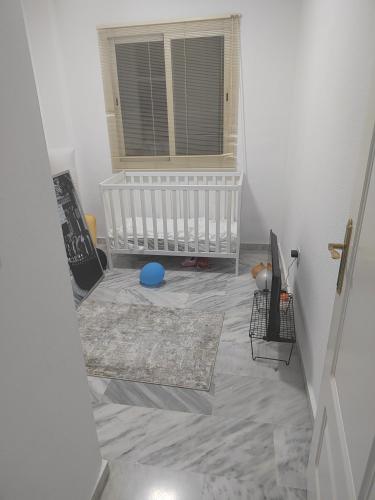 Habitación con cuna y bola azul en el suelo en pueblo, en Benalmádena