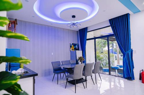 una sala da pranzo con tavolo e tende blu di Pao Homestay a Hue
