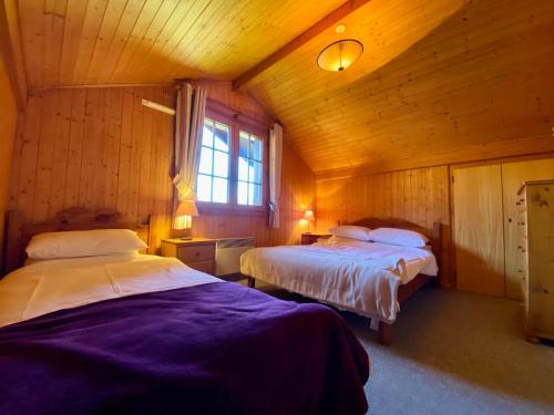 - une chambre avec 2 lits dans une cabane en bois dans l'établissement Charmant duplex à Morillon, proche centre, 3 ch, 9 pers, parking, ski - FR-1-624-174, à Morillon