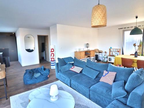 a living room with a blue couch and a table at Maison neuve spacieuse à Groix, proche du Bourg - FR-1-813-4 in Groix