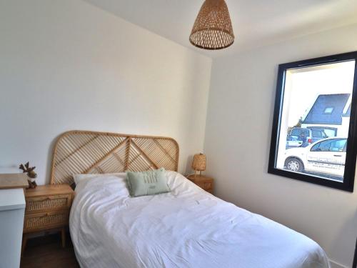 a bedroom with a white bed and a window at Maison neuve spacieuse à Groix, proche du Bourg - FR-1-813-4 in Groix