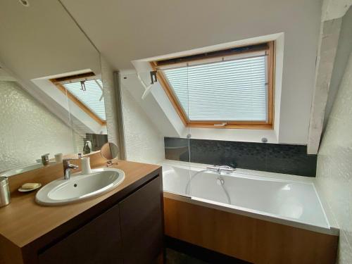 a bathroom with a sink and a bath tub at Charmante maison familiale à Groix, 3 chambres - FR-1-813-5 in Groix