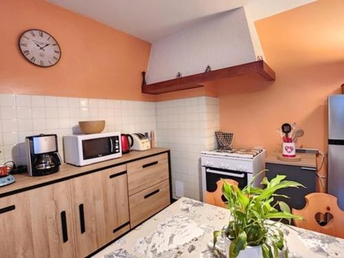 une cuisine avec une horloge murale dans l'établissement Grand appartement entre pistes à La Chapelle d'Abondance avec balcon et parking - FR-1-692-108, à Abondance
