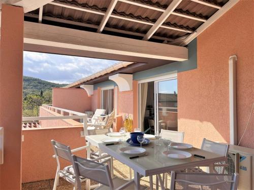 d'une table et de chaises sur une terrasse avec balcon. dans l'établissement Appt climatisé 3 pièces - 6 pers - Terrasse, parking à 200m de la plage - FR-1-251-845, au Lavandou