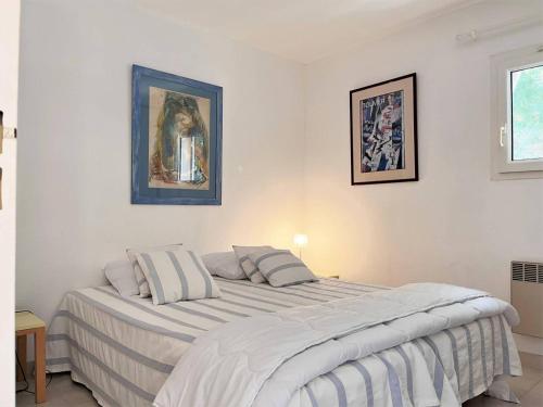 - une chambre blanche avec un grand lit et 2 oreillers dans l'établissement Appt climatisé 3 pièces - 6 pers - Terrasse, parking à 200m de la plage - FR-1-251-845, au Lavandou