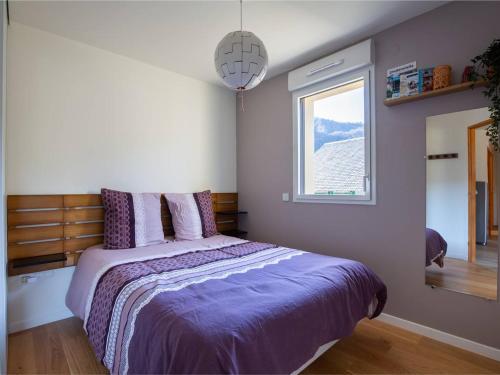 a bedroom with a bed with purple sheets and a window at Appartement moderne 4 pers, proche SkyVall, parking gratuit - FR-1-695-63 in Loudenvielle
