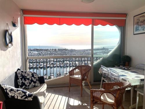 Cette chambre dispose d'un balcon avec une table et une grande fenêtre. dans l'établissement La Grande Motte: Appart 2 pers, Clim, Parking - FR-1-790-33, à La Grande Motte