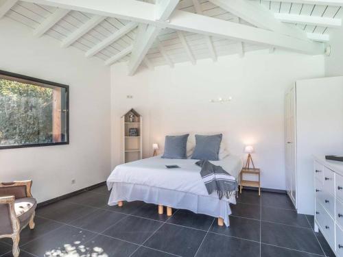 une chambre blanche avec un lit et une chaise dans l'établissement Villa d'exception pour 10 pers avec piscine chauffée et parking privé à Labenne - FR-1-791-28, à Labenne