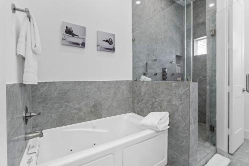 a white bathroom with a tub and a shower at Spacious Houston 3Bed3 Bath Family Townhome in Houston
