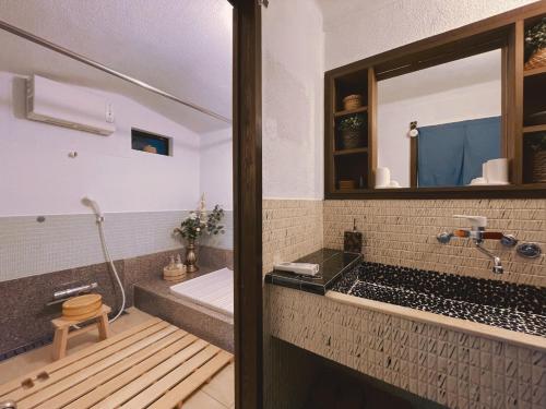 a bathroom with a tub and a mirror at Rakumankan in Kyoto