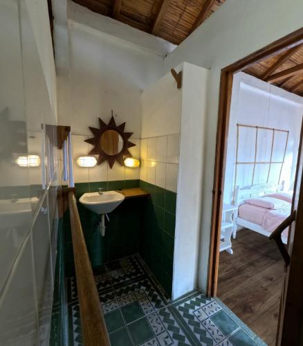 a bathroom with a sink and a mirror at La Perla Hostel and Cabins in Las Tunas