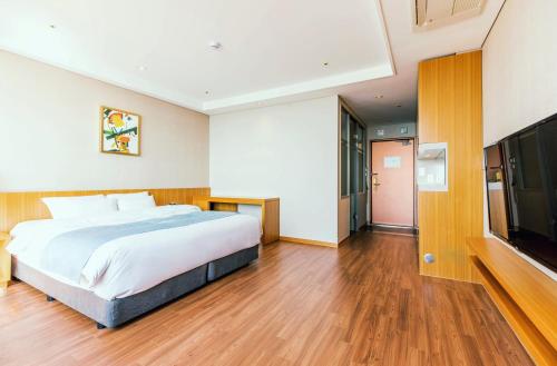 a bedroom with a large bed and a flat screen tv at Hotel solaire in Boryeong