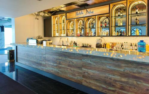 a bar with a wooden counter top in a room at OYSTER BAY HOTEL VUNG TAU in Vung Tau