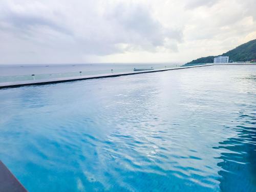 a pool of water with a beach in the background at OYSTER BAY HOTEL VUNG TAU in Vung Tau