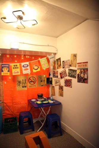 a room with a table and stools and posters on the wall at Pyeongtaek 1981 in Pyeongtaek
