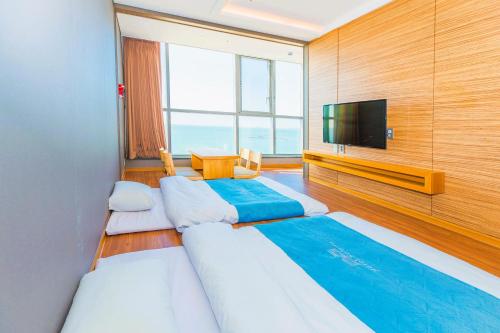 a bedroom with two beds and a flat screen tv at Hotel solaire in Boryeong