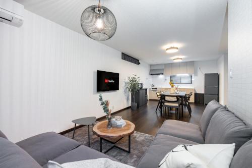a living room with a couch and a table at SWEET VILLA HAKU Tengachaya in Osaka