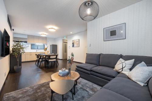 a living room with a couch and a table at SWEET VILLA HAKU Tengachaya in Osaka