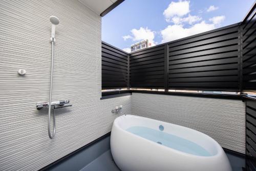 a bathroom with a bath tub and a sink at SWEET VILLA HAKU Tengachaya in Osaka
