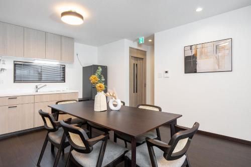a dining room with a wooden table and chairs at SWEET VILLA HAKU Tengachaya in Osaka