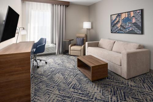a living room with a couch and a table in a hotel room at Candlewood Suites Chattanooga - East Ridge by IHG in Chattanooga