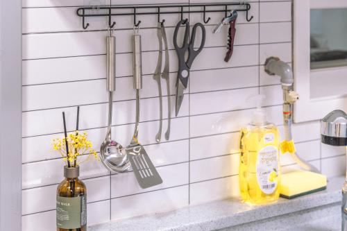 a kitchen counter with utensils hanging on a wall at 인천 간석동 머니스테이 in Incheon