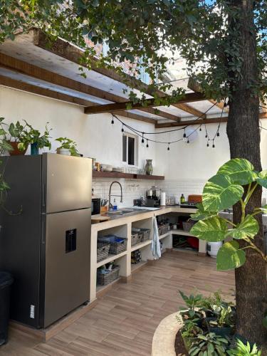 a kitchen with a refrigerator and a tree at Private Room in a Boho House N1 in Puerto Vallarta