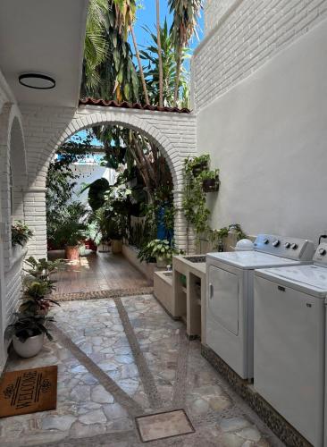 an outdoor kitchen with white appliances and a stone floor at Private Room in a Boho House N1 in Puerto Vallarta