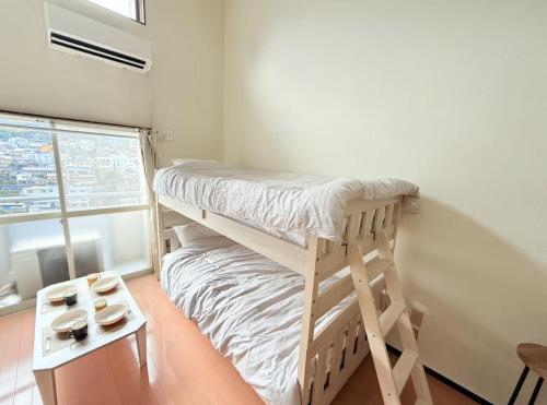 a small bedroom with a bunk bed and a table at 高平ハウス Room106 in Nagasaki